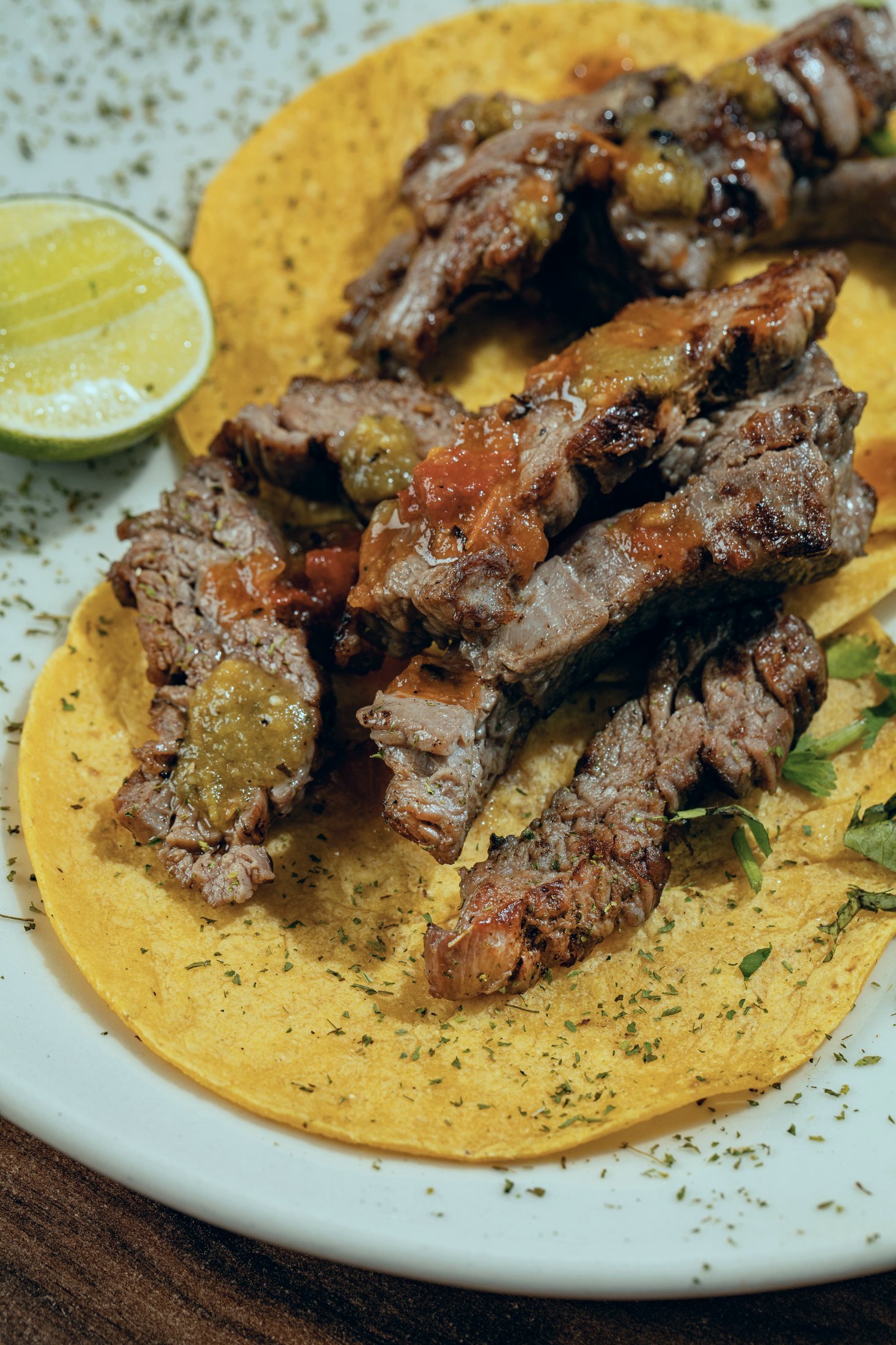 Mesa servida con tacos, cortes y cocteles